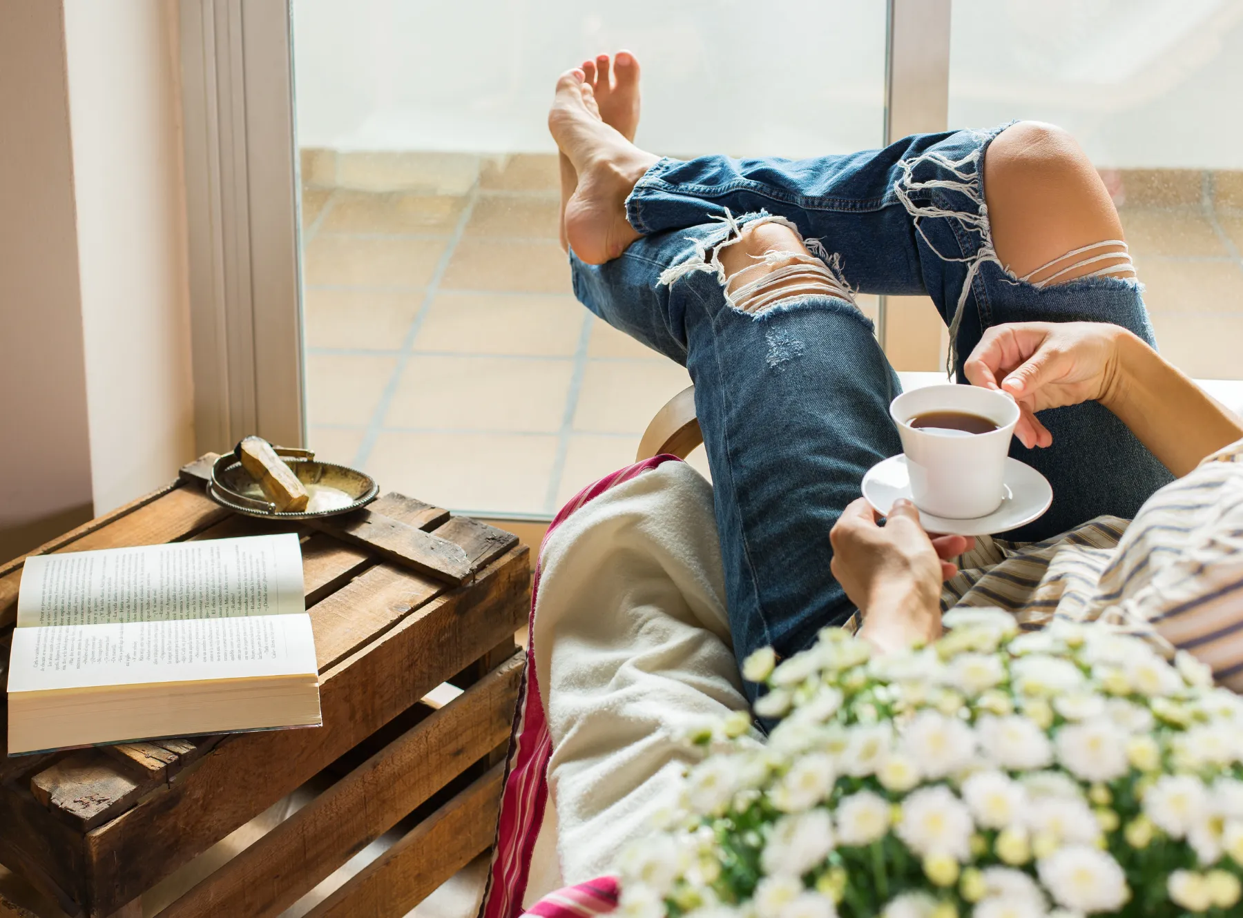 Woman with legs out drinking tea/coffee