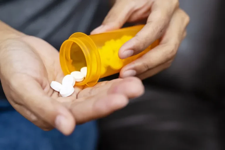 Pills flowing out of a bottle into a persons hand