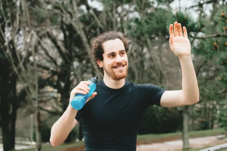 Man outdoors with arm raised
