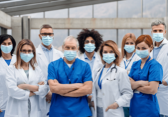 Blog header photo for Physician Health & Wellness in the Era of COVID-19: Mental Health Effects of the COVID-19 Pandemic on Physicians, depicting a group of healthcare practitioners wearing masks